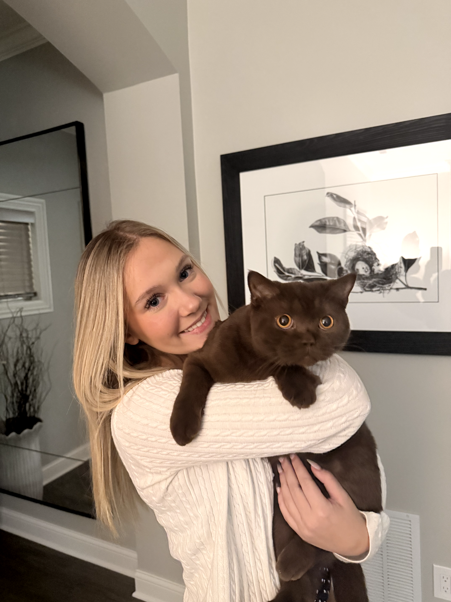 Y smiling and holding her chocolate-brown cat